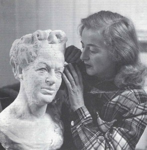 Betty working on a bust of Gracie (inn her best clothes).